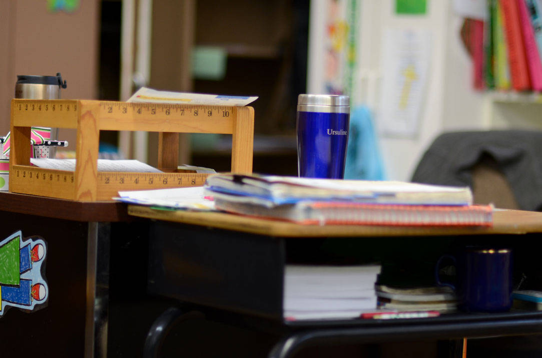 Teacher's desk with an Ursuline travel coffee mug on top