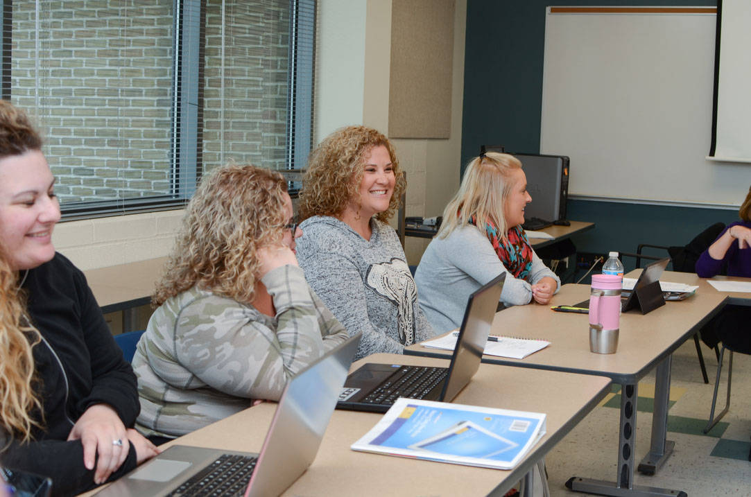 Three students engaging in conversation during class