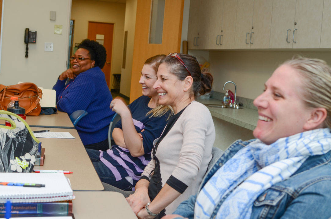 Four students laugh during class