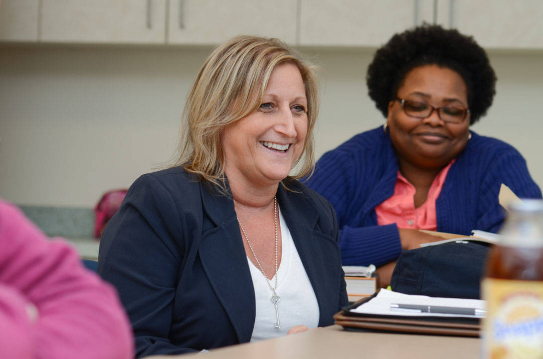 Two nursing students smile during class