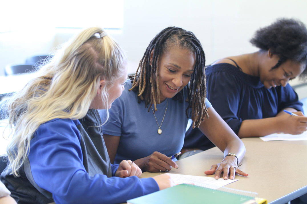 Education professor works with student on assignment