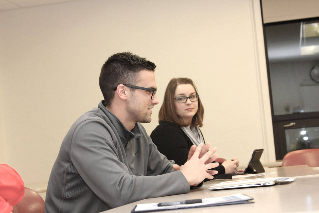 Student speaks during class while classmate listens
