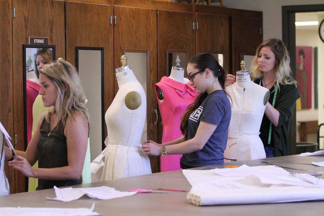 Fashion design degree student measuring form and draping fabric