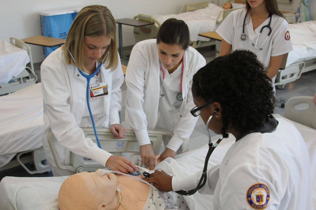 Accelerated nursing program students in Ohio practice using stethoscopes