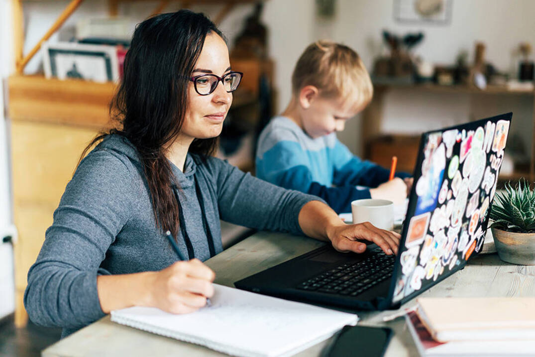 Ursuline Accelerated Adult Business student studying at home with child
