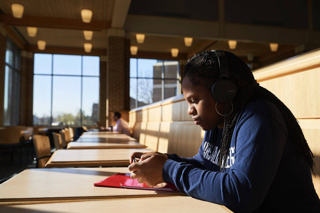 A student relaxes before class in the Pilla Atrium.