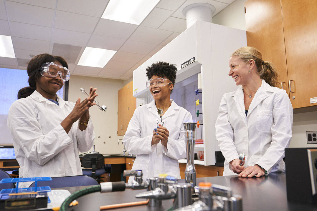 Students learn how to ignite burner in biology lab 