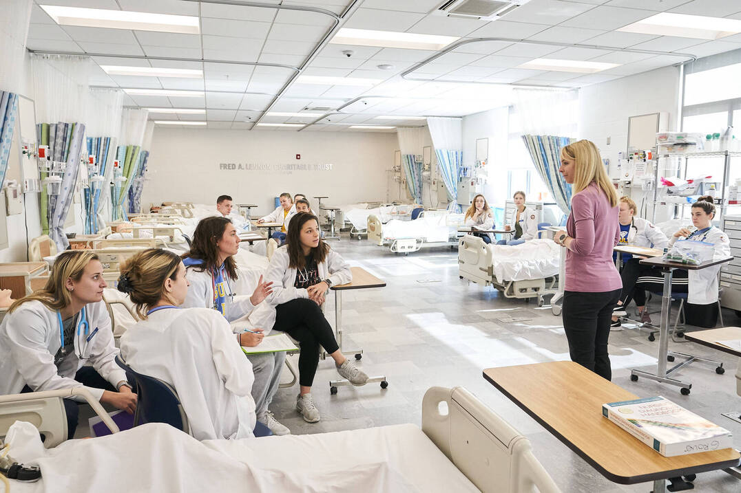 Nursing students in learning lab with professor