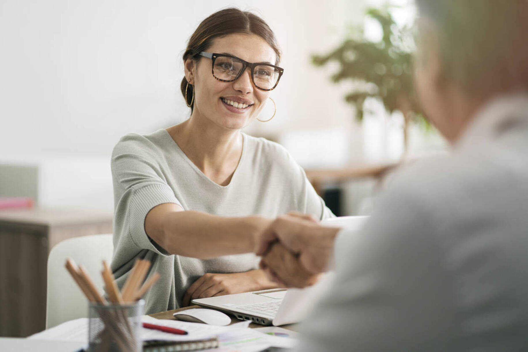 Financial planner shakes hands with client