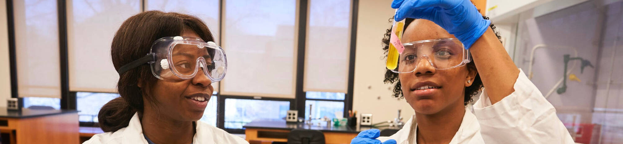 Two students looking at beaker
