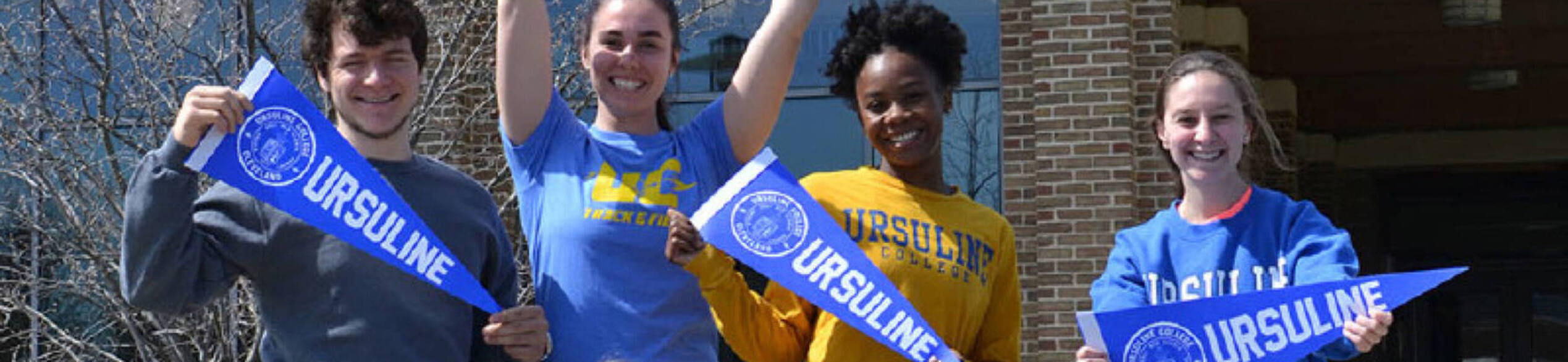 Ursuline college students holding penants