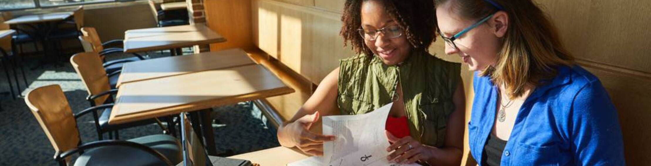 Two students look at a book at Ursuline College